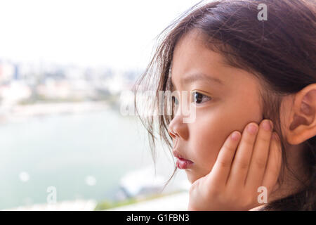 Trauriges Mädchen Blick aus Fenster wartet auf jemanden. Stockfoto