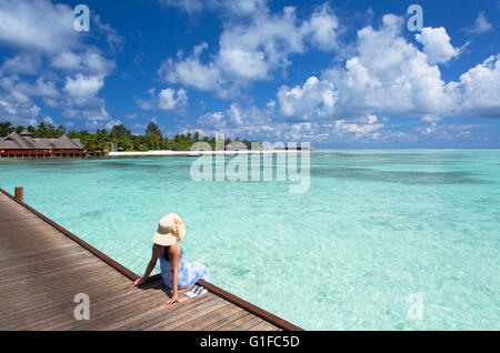 Frau am Pier in Olhuveli Beach Resort &amp; Spa, Süd Male Atoll, Kaafu Atoll, Malediven) Stockfoto