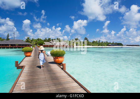 Frau am Pier in Olhuveli Beach und Spa Resort, Süd Male Atoll, Kaafu Atoll, Malediven Stockfoto