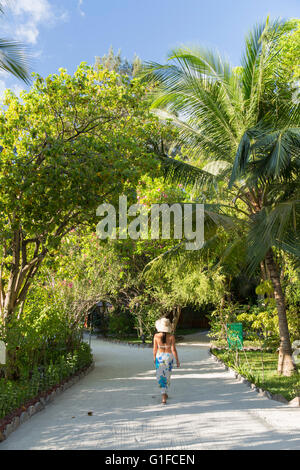 Frau zu Fuß im Gelände des Olhuveli Beach und Spa Resort, Süd Male Atoll, Kaafu Atoll, Malediven Stockfoto