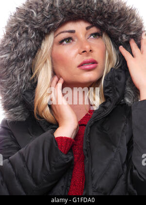 Ein attraktives blondes Modell trägt einen Wintermantel mit Kapuze. Stockfoto