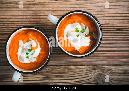 Kürbissuppe in weiße Tasse auf einem Holztisch, Ansicht von oben Stockfoto