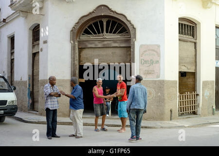 Einheimische Männer tauschen Grüße außerhalb Cafe Alma in Alt-Havanna, Havanna, Kuba Stockfoto