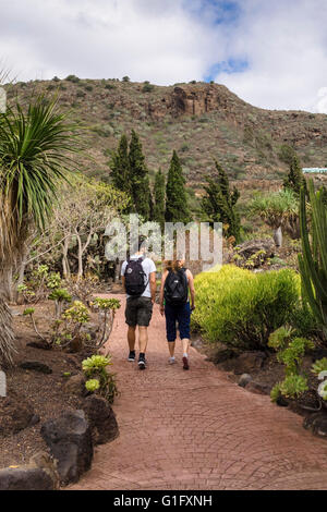 Rückansicht des Touristen zu Fuß durch den Kaktusgarten (Jardín de Cactus y Sucelentas) im Botanischen Garten von Gran Canaria Stockfoto