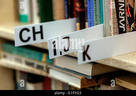 Alphabetische Sortierung von Büchern, die in den Regalen liegen, Bibliotheksbücher im Regal Stockfoto