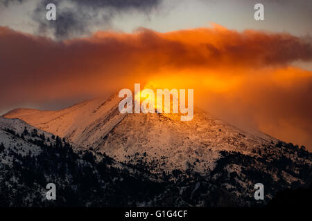 Landschaft von Winter-Berg bei Sonnenauf- oder Sonnenuntergang mit goldene Lichtstrahlen der Sonne Peak in Griechenland Stockfoto