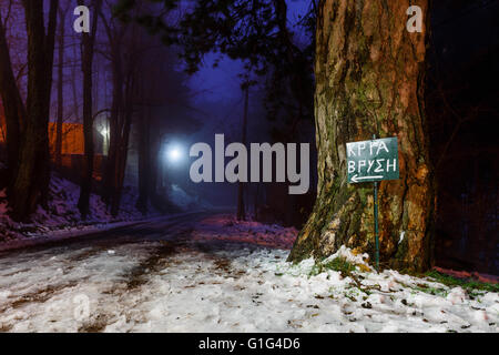 Schönes Licht und Schatten verschwinden in entfernten Straße mit Bäumen und Schild mit der Aufschrift "Cold Spring', Winter-Szene in Griechenland Stockfoto