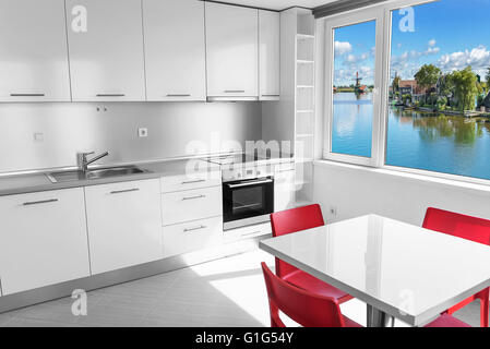 Moderne weiße Küche Interieur mit Blick auf den See im Fenster. Stockfoto