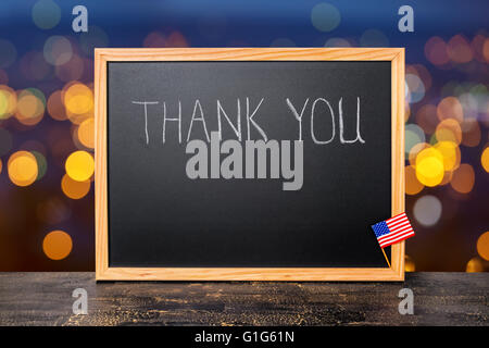 Handschrift Text danke ist in Tafel mit Flagge auf hellem Hintergrund Stadt und Craquelure schwarze Brett geschrieben, Nahaufnahme Stockfoto