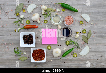 Essen-Hintergrund. Bunte leere Aufkleber für Notizen und Pfeffer, Lorbeer, Rosmarin, Zwiebeln, Himalaya-Salz, Olivenöl, Soja-sauce Stockfoto