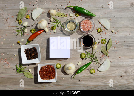 Essen-Hintergrund. Bunte leere Aufkleber für Notizen und Pfeffer, Lorbeer, Rosmarin, Zwiebeln, Himalaya-Salz, Olivenöl, Soja-sauce Stockfoto