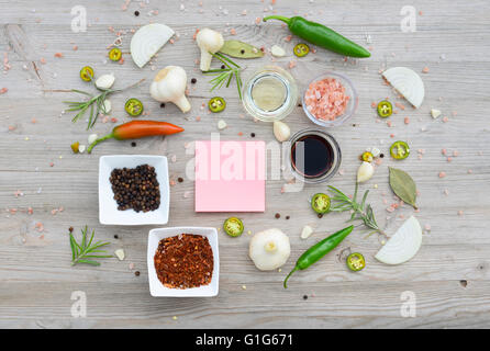 Essen-Hintergrund. Bunte leere Aufkleber für Notizen und Pfeffer, Lorbeer, Rosmarin, Zwiebeln, Himalaya-Salz, Olivenöl, Soja-sauce Stockfoto