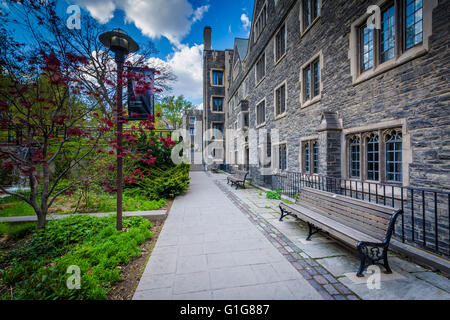 Eine Bank und die Burwash Wohnhaus über einen Fußweg an der Victoria University, an der University of Toronto in Toronto, Ont Stockfoto