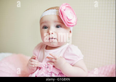 Porträt der niedliche kleine Baby-Mädchen mit rosa Schleife Blume auf dem Kopf Stockfoto