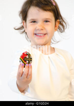 Süßes kleines Mädchen Halt ein Osterei bemalt isoliert auf weißem Hintergrund Stockfoto