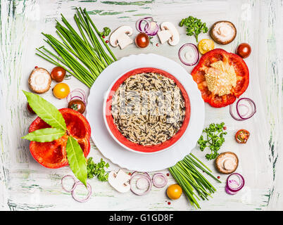 Wilder Reisgericht und verschiedene Gemüse und Gewürz-Zutaten für leckere vegetarisch Kochen auf rustikalen hölzernen Hintergrund, Stockfoto