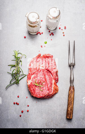 Rohes Fleisch Steak Vorbereitung auf grauem Stein Hintergrund, Ansicht von oben Stockfoto