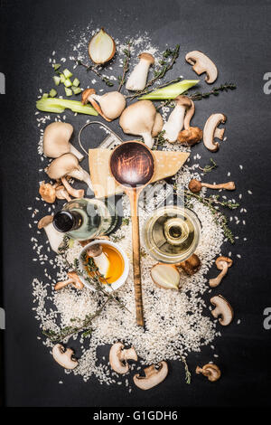 Kochzutaten für Pilze Risotto auf dunklem Hintergrund, Ansicht von oben. Italienisches Essen Stockfoto