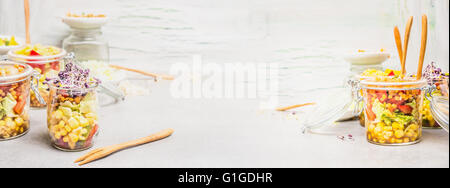 Auswahl an Salaten in Glas Gläser für Take away Mittagessen oder Picknick am hellen Holz Hintergrund, Seitenansicht, Banner. Gesund und clea Stockfoto