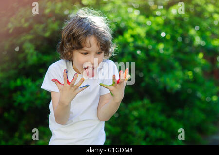 Kind mit seinen Händen in der Farbe, Zunge Stockfoto