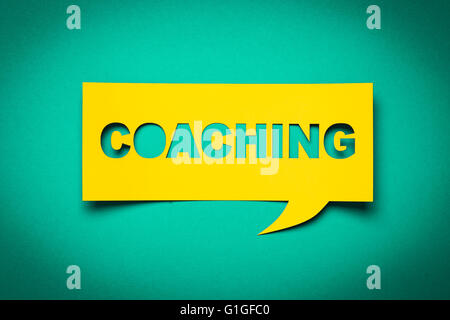 Blase Rede mit Ausschneiden Phrase "coaching" in der Zeitung. Stockfoto