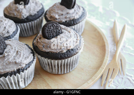 Hausgemachte dunkle Schokolade Cupcakes mit Cookie und Creme Zuckerguss Stockfoto