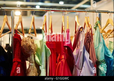 Abendkleider hängen auf einem Regal im Laden Stockfoto