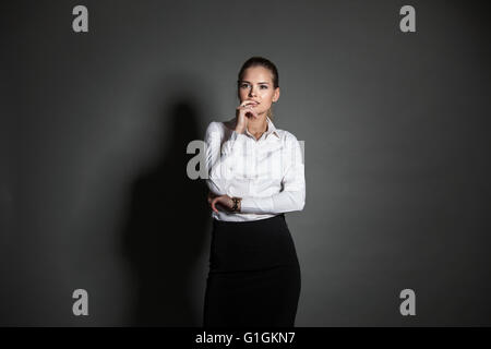 Porträt der jungen Unternehmerin auf dunklem Hintergrund Stockfoto