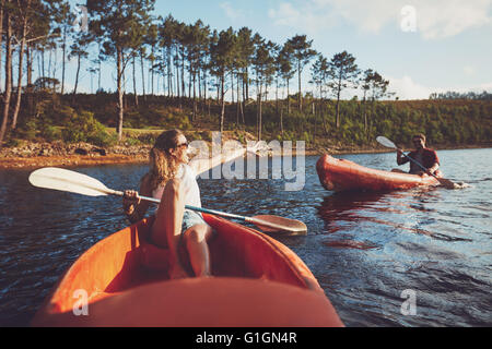 Junges Paar Kanufahren auf dem See. Junge Kanuten einen Tag am See zu genießen. Stockfoto