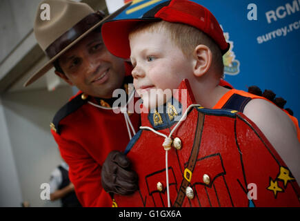 (160515)--VANCOUVER, 15. Mai 2016 (Xinhua)--A junge posiert für Fotos mit einem Polizisten während einer Veranstaltung Tag der offenen Tür anlässlich der jährlichen nationalen Polizei Woche an die Royal Canadian Mounted Police (RCMP) die wichtigsten Ablösung in Surrey, Kanada, 14. Mai 2016. (Xinhua/Liang Sen) Stockfoto