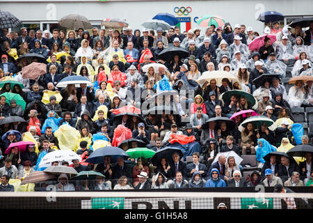 Zuschauer beobachten Tennis im Regen mit Sonnenschirmen in Rom Stockfoto