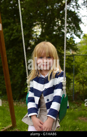 junges Mädchen sitzen auf Schaukel Stockfoto