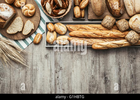 Frisch gebackenes leckeres Brot auf eine rustikale Holz-Arbeitsplatte mit Textfreiraum, gesunde Ernährung Konzept, flach zu legen Stockfoto