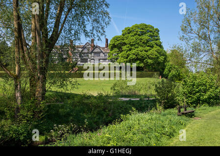 Bramall Hall in der Nähe von Stockport, umgeben von einem schönen Park. Eine Weide im Vordergrund. Stockfoto