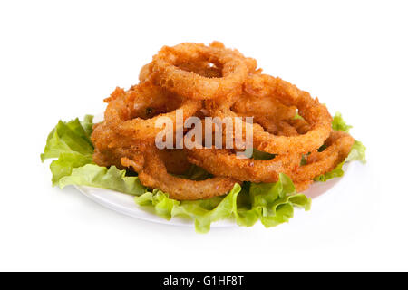 Gebratene Zwiebelringe auf Salatblatt und weiße Platte isoliert auf weißem Hintergrund. Stockfoto
