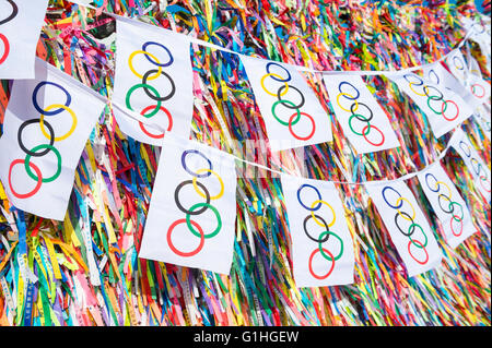 SALVADOR, Brasilien - 11. März 2015: Olympische Flagge Bunting hängt vor dem Hintergrund des guten Glücks brasilianische wünschen Bänder. Stockfoto