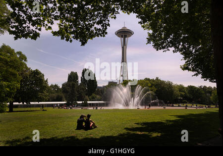 Ein paar sitzt auf der Wiese in der Nähe von International-Brunnen und die Space Needle in Seattle, Washington, USA (Adrien Veczan) Stockfoto
