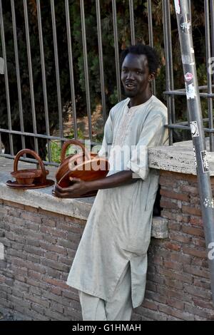 Ein afrikanischer Mann verkaufen Hand made Güter auf der Straße in Rom Stockfoto