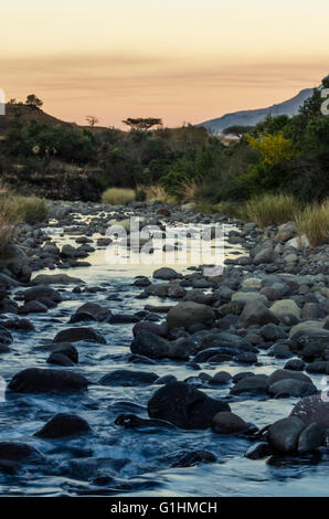 Sonnenuntergang über dem Fluss in der Nähe von Cathedral Peak, Drakensberge, KwaZulu Natal, Südafrika Stockfoto