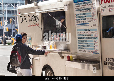 Männliche Kunden bestellen bei einem Food Truck in der Innenstadt von Toronto, Ontario, Kanada Stockfoto