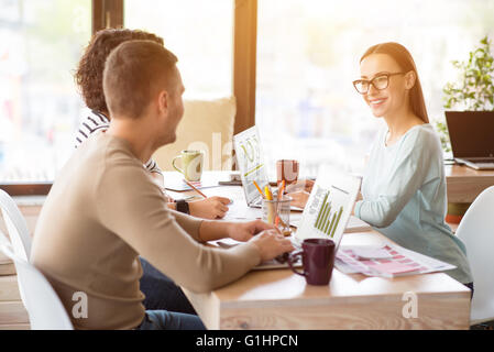 Fröhlichen Kollegen arbeiten auf dem Tisch Stockfoto