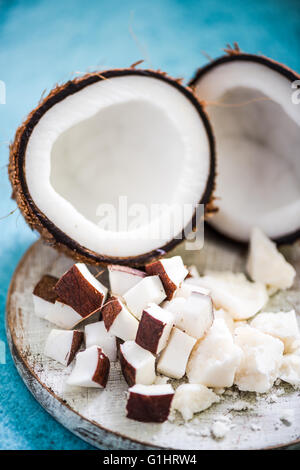 Kokos-Stücke und Butter auf Holzbrett, gesunde und natürliche Medizin Stockfoto