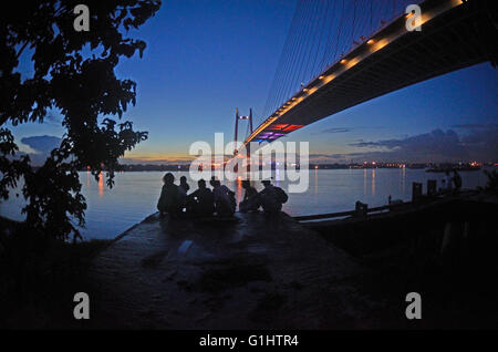 Sonnenuntergang am Hooghly River mit beleuchteten Second Hooghly Bridge, Kolkata, Westbengalen, Indien Stockfoto