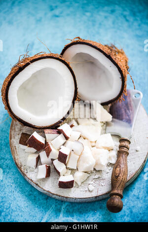 Kokos-Stücke und Butter auf Holzbrett, gesunde und natürliche Medizin Stockfoto