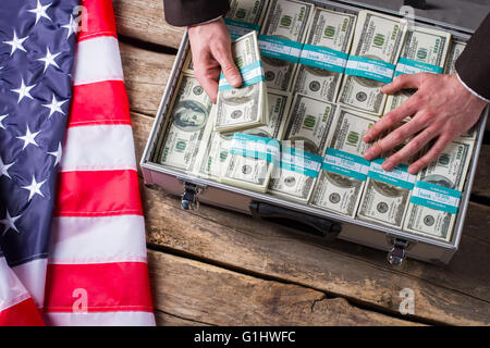 Hand berührt Dollar im Koffer. Stockfoto