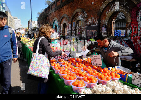 Frau kaufen Obst und Gemüse aus einem Marktstand in shoreditch Stockfoto