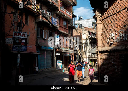 Die Einheimischen passieren eine Gasse in der Altstadt von Bhaktapur, Nepal. Stockfoto