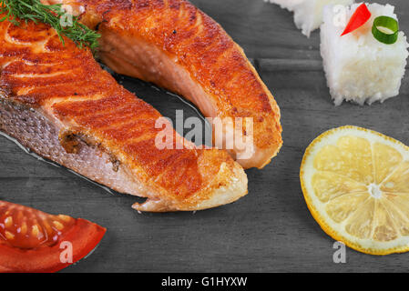 Gegrillter Lachs mit Gemüse und Reis auf hölzernen Hintergrund Stockfoto