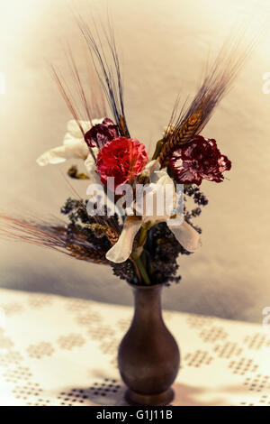 Vase mit getrockneten und frischen Blumen in einem altem Stil verblasst. Stockfoto