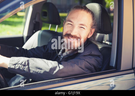 Lächelnd asiatischen Mann als Fahrer des modernen japanischen Suv, Outdoor-Porträt in offenen Autofenster, stilisierte Vintage Foto mit tonalen cor Stockfoto